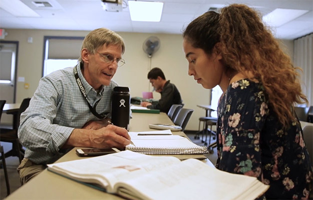 Professor Will Kraske helping a student in a classroom