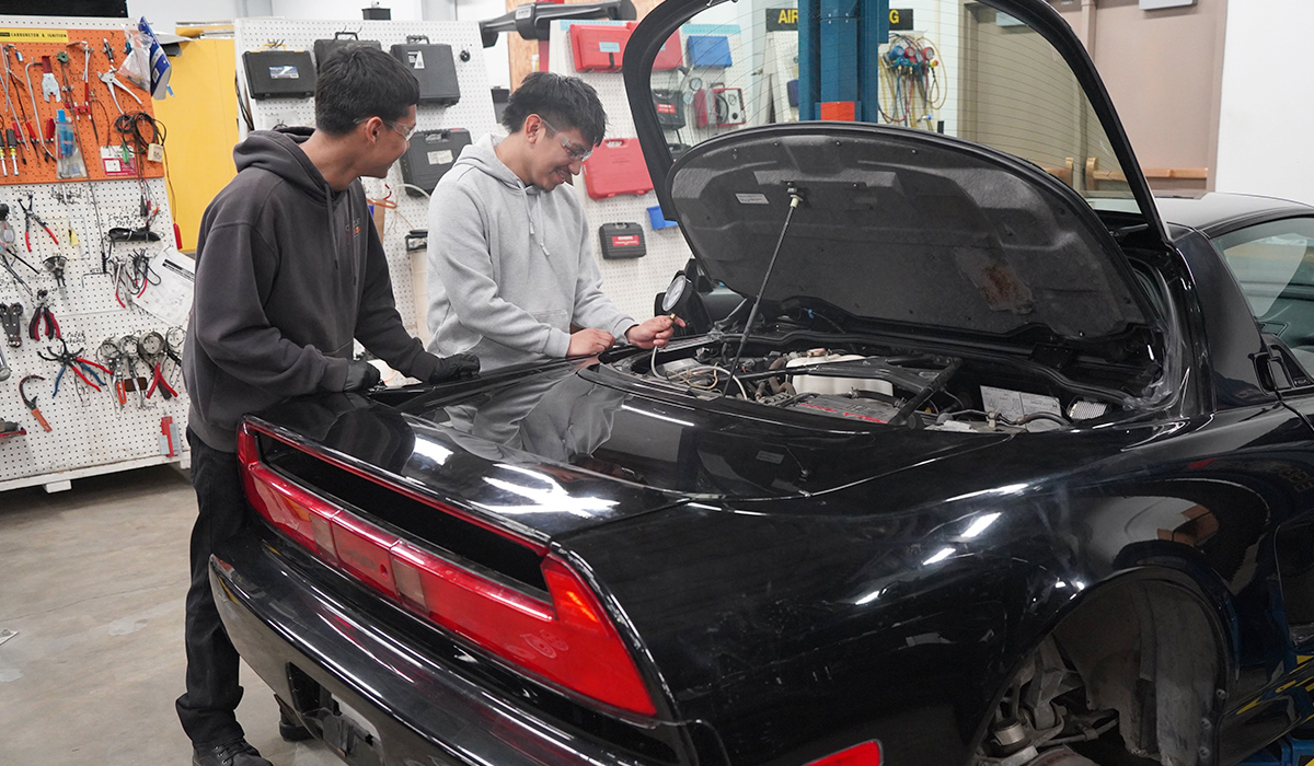 Two WVC auto tech students run a test on a car's engine.