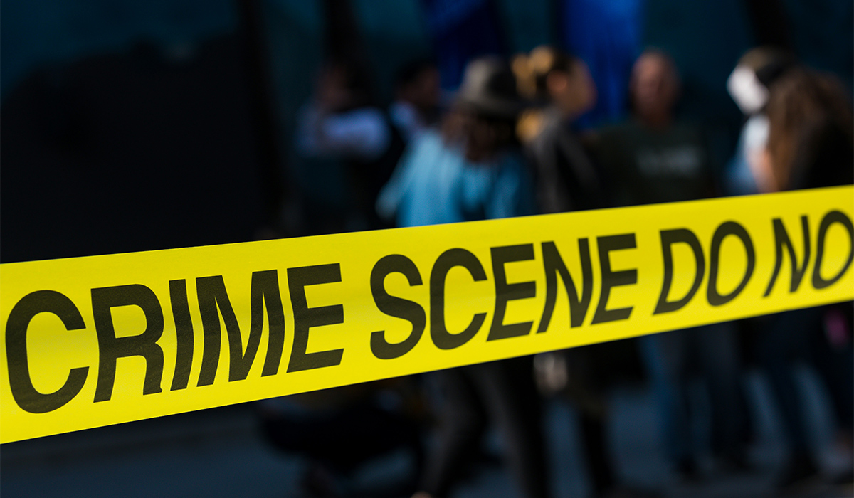 A yellow Crime Scene rope with a dark background.