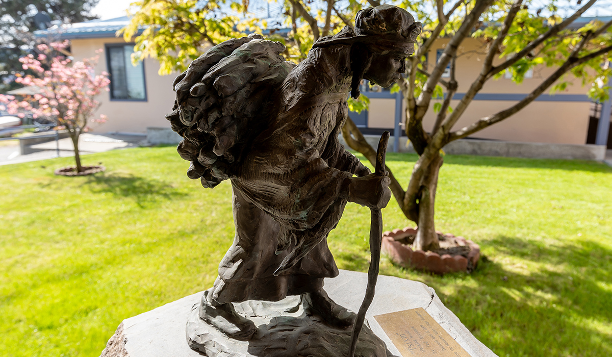 A statue of a Native American person on the WVC Omak campus.