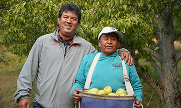 Apolinar and Francisco holding pears.