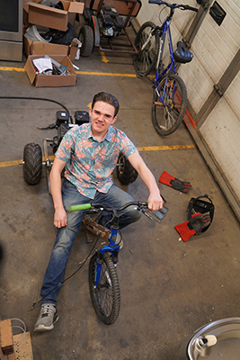 Cash Fowler sits on a go-kart in the Industrial Technology shop.