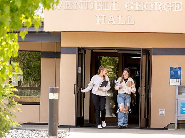 Two students walk out the entryway to Wendell George Hall on the WVC Omak campus.