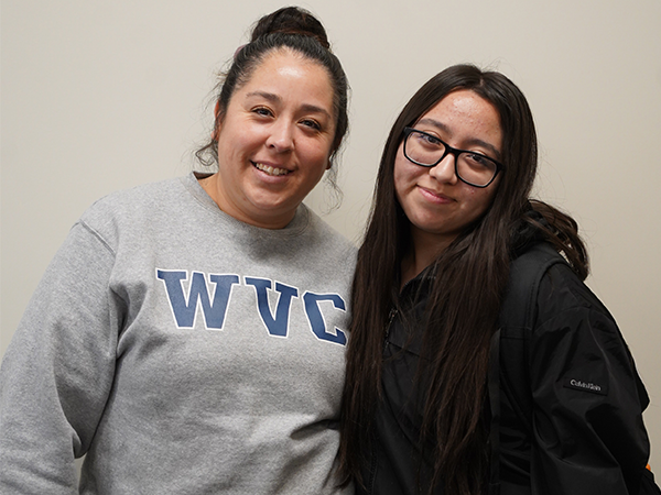 Two female students smile at the camera